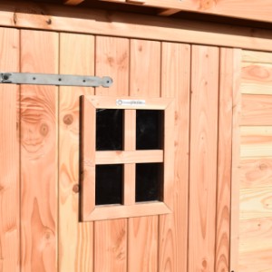 Die Tür des Hundezwingers ist mit einem Fenster und robusten Metallscharnieren ausgestattet